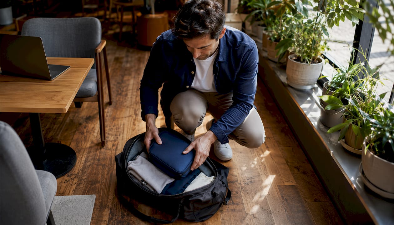 Traveler packing laundry bag in suitcase